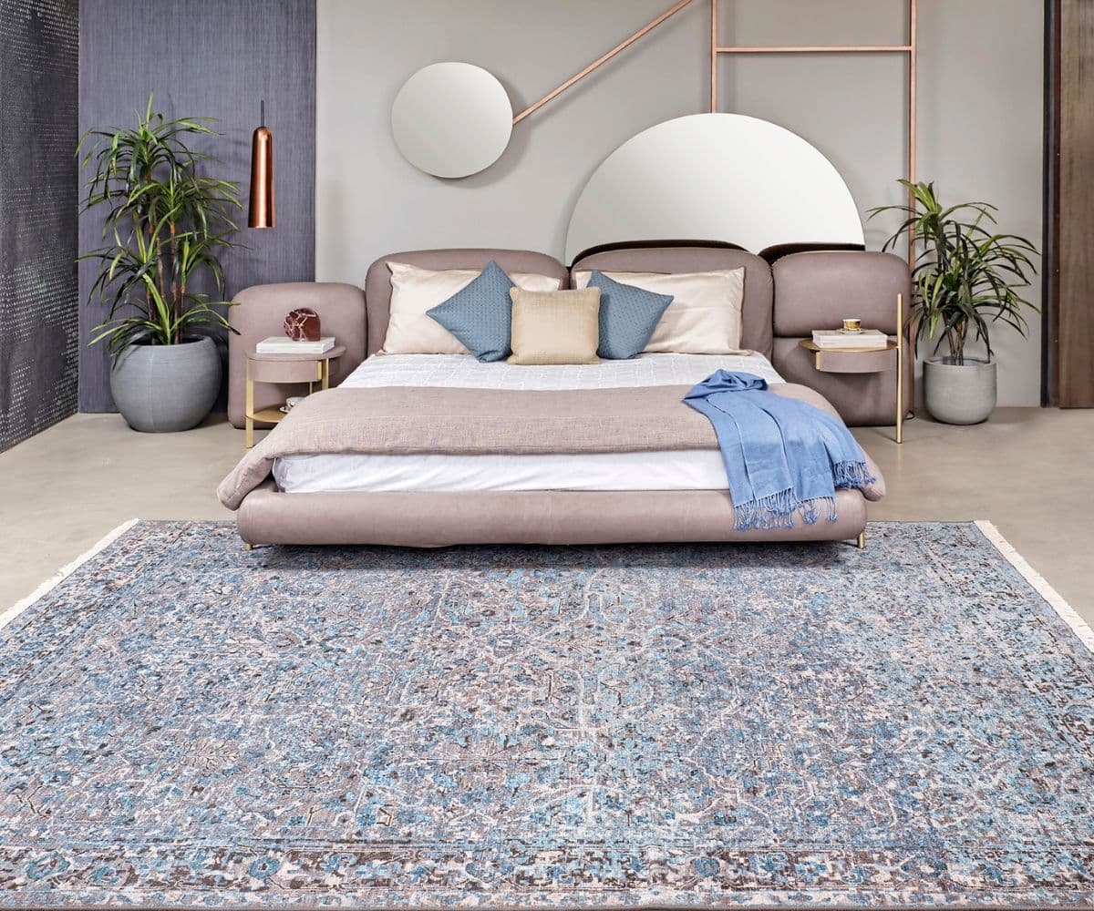 An antique hand-knotted rug beneath a pair of accent chairs in a styled living room
